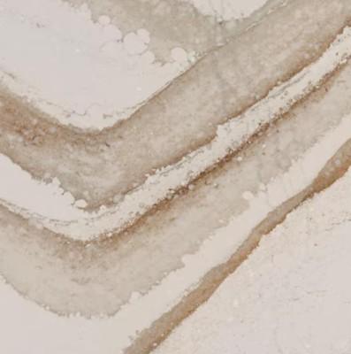 Light brown and beige wavy stains on a white surface, resembling coffee or tea rings on paper.