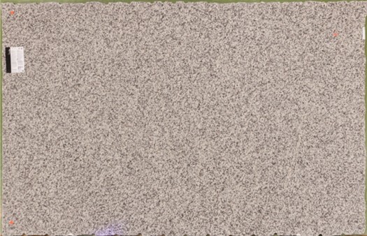 A large rectangular slab of light gray granite with a fine, speckled black and white pattern.